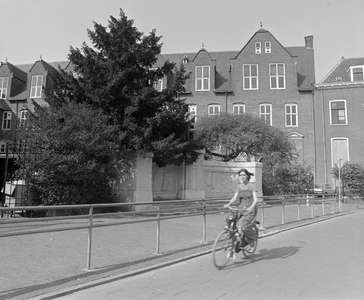 882272 Afbeelding van een fietster op het Janskerkhof te Utrecht, met op de achtergrond het monument van prof. F.C. Donders .